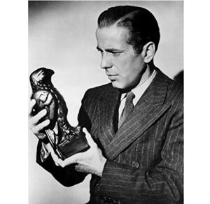 humphrey bogart as samuel holding and looking at maltese falcon statue the maltese falcon 8 x 10 inch photo