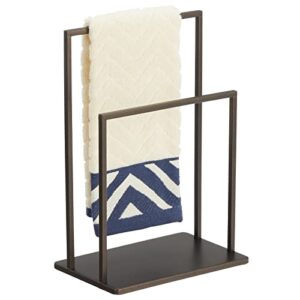 mdesign modern decorative metal fingertip towel holder stand for bathroom vanity countertops to display and store small guest towels or washcloths - 2-sided - bronze