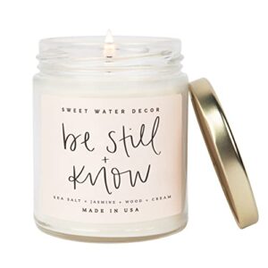sweet water decor, be still and know, sea salt, jasmine, cream, and wood scented soy wax candle for home | 9oz clear jar, 40 hour burn time, made in the usa