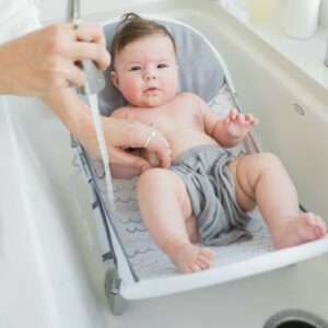 The First Years Sure Comfort Folding Baby Bather - Baby to Toddler Bath Tub - No-Slip Seat - for Sink or Tub Use