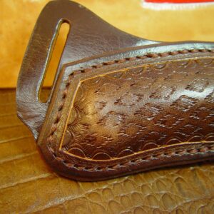 Custom left hand cross draw knife sheath for a buck 110 knife. The sheath is made out of buffalo hide leather hand tooled with a basket weave pattern.