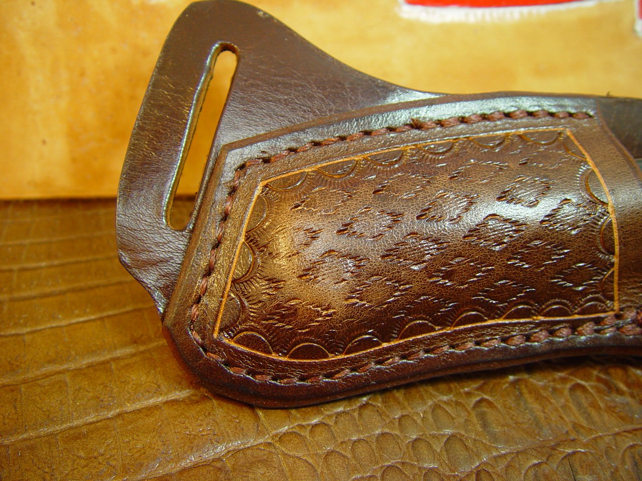 Custom left hand cross draw knife sheath for a buck 110 knife. The sheath is made out of buffalo hide leather hand tooled with a basket weave pattern.