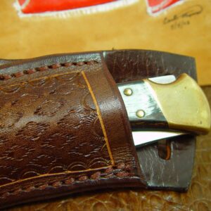 Custom left hand cross draw knife sheath for a buck 110 knife. The sheath is made out of buffalo hide leather hand tooled with a basket weave pattern.