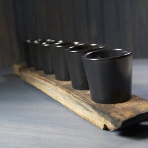 WHISKEY BARREL SHOT PADDLE WITH BLACK CERAMIC SHOT GLASSES - Black Ceramic shot glasses with a reclaimed whiskey barrel shot paddle and leather handle, 6 shot glasses/sake cups included