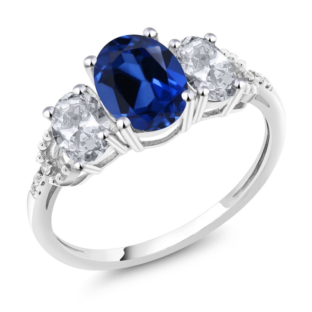 Gem Stone King 10K White Gold Blue Created Sapphire White Topaz and Diamond Accent 3 Stone Engagement Ring For Women (2.65 Cttw) (Size 8)