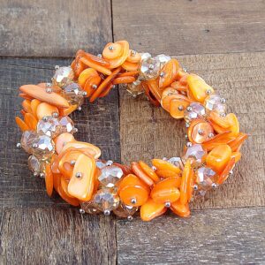 Calisa Designs Woman's orange shell and glass beaded stretch bracelet with silver beads, Designed with clusters of orange shell and orange facet cut glass beads.